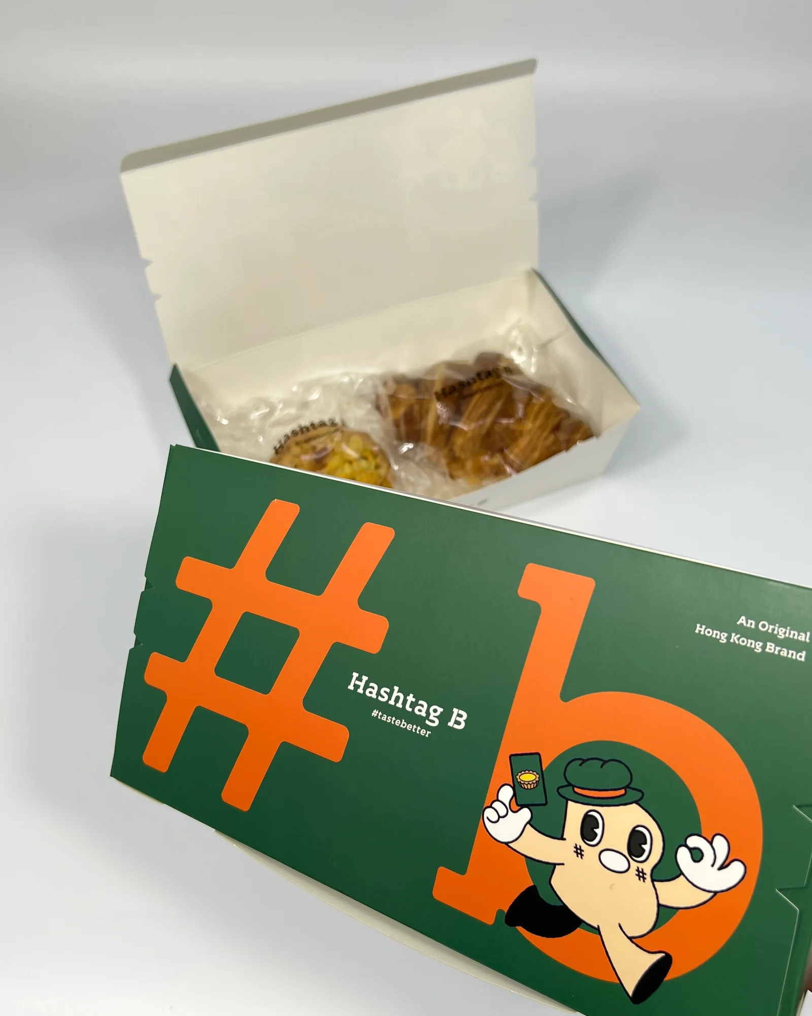 打開嘅 Hashtag B 酥點盒,入面有牛角包,綠色盒蓋印 #、b 同吉祥物