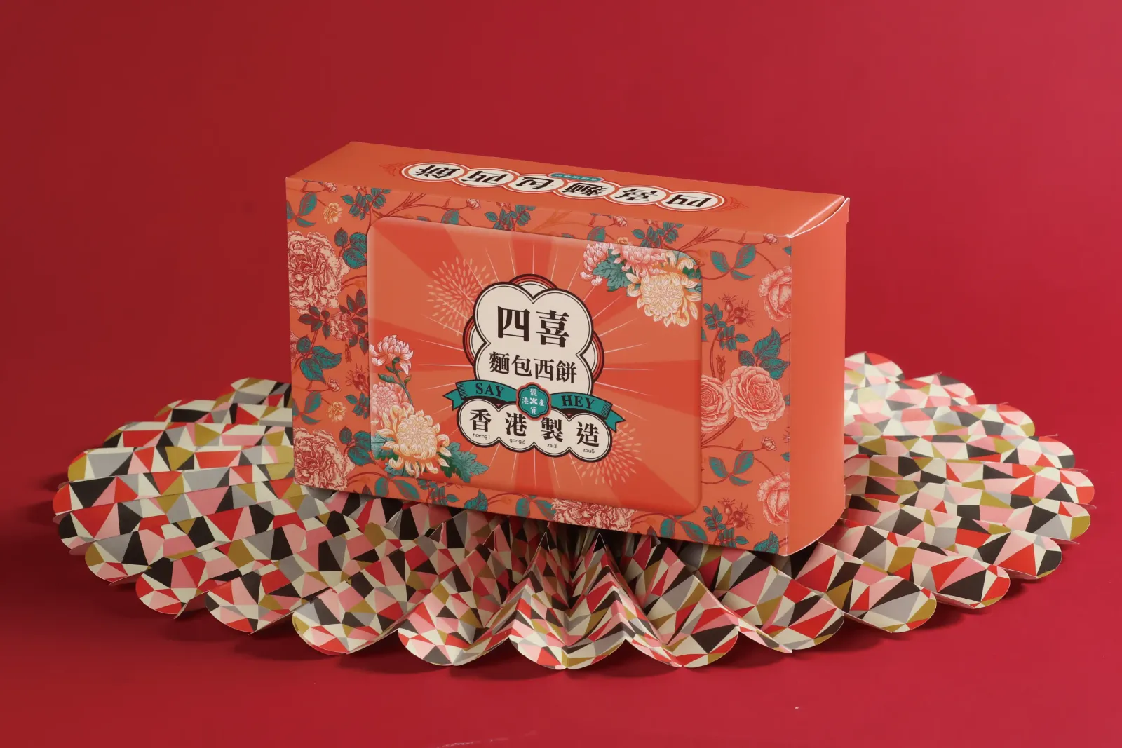 橙色花卉四喜蝴蝶酥雙插盒，有「香港製造」徽章，紅色背景
