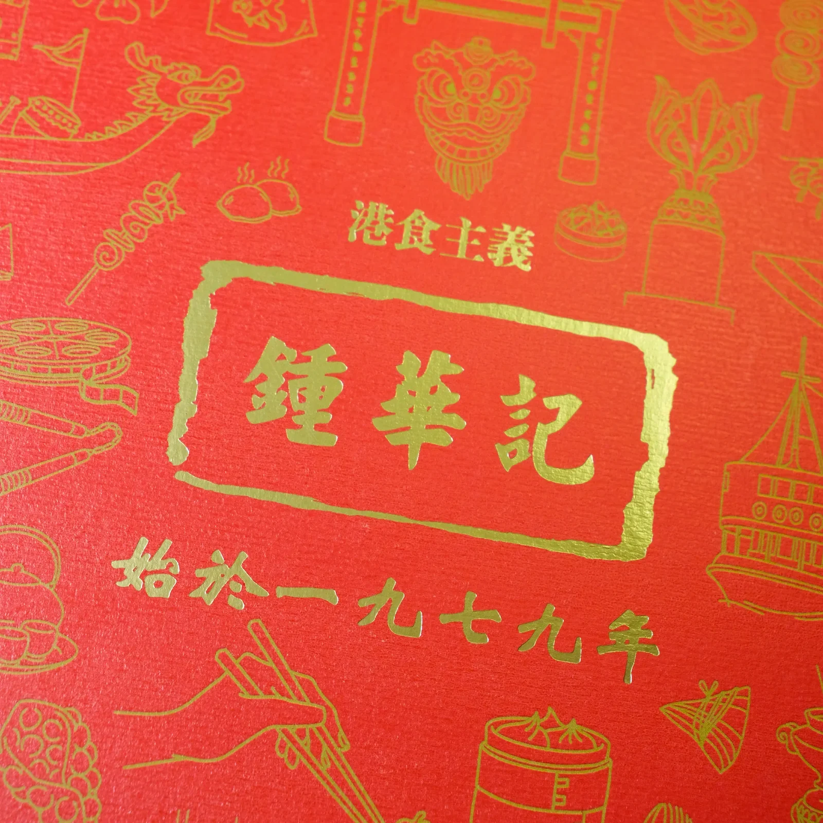硬盒盒蓋上嘅燙金印章:港食主義 · 鍾華記 · 始於一九七九年